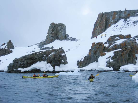 Nosso grupo rema ao lado das encostas de Half Moon Island, na Antártida